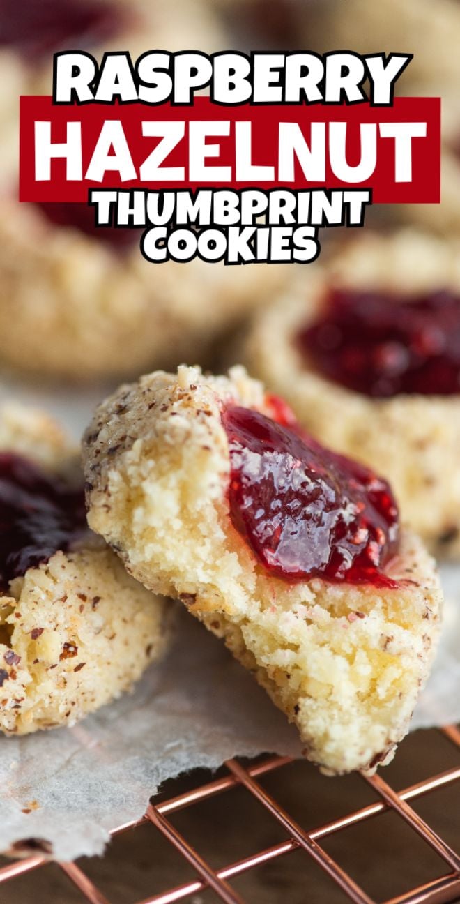 Close-up of classic thumbprint cookies with a raspberry jam filling, these raspberry hazelnut thumbprint cookies cool on a rack, showcasing their delicious homemade charm.