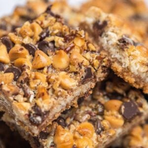 Close-up of coconut squares topped with chocolate chips, butterscotch chips, and chopped nuts—classic Hello Dolly bars for a nostalgic treat.