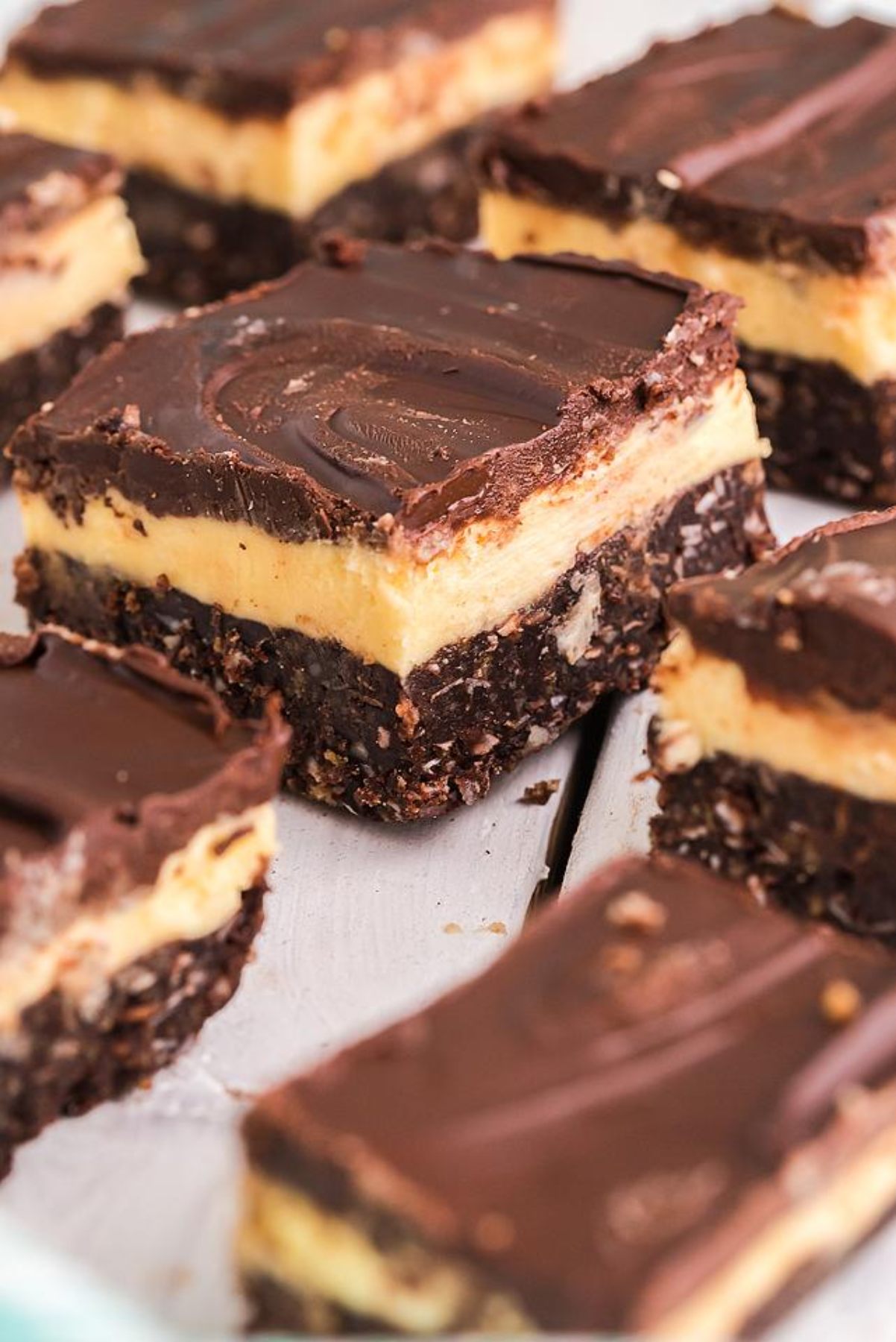 Close-up of classic Canadian dessert Nanaimo bars, featuring rich chocolate and custard layers on a light surface—bars that freeze well and taste delicious.