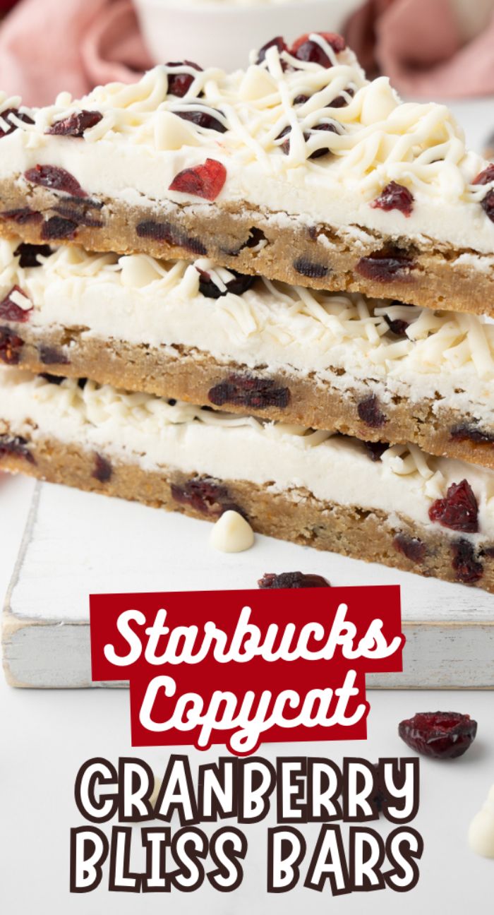 Three easy cranberry bars stacked, topped with white chocolate drizzle and dried cranberries—a perfect Starbucks copycat cranberry bliss bars recipe.