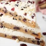 Three stacked Starbucks copycat cranberry bliss bars with creamy topping sit on a white surface—these easy cranberry bars are the perfect homemade bliss bars for any dessert lover.