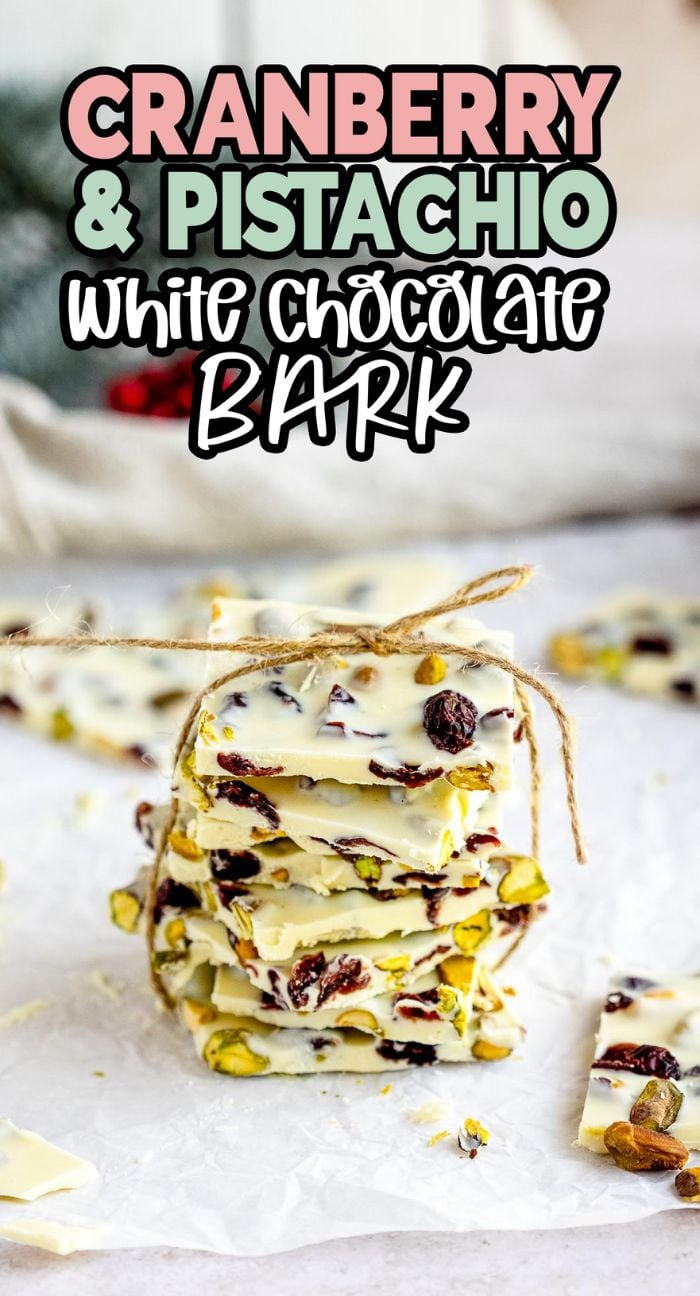 Stack of Cranberry Pistachio White Chocolate Bark, like almond bark, tied with twine on a white surface—perfect for gifting or enjoying as festive Christmas bark with pistachios and cranberries.