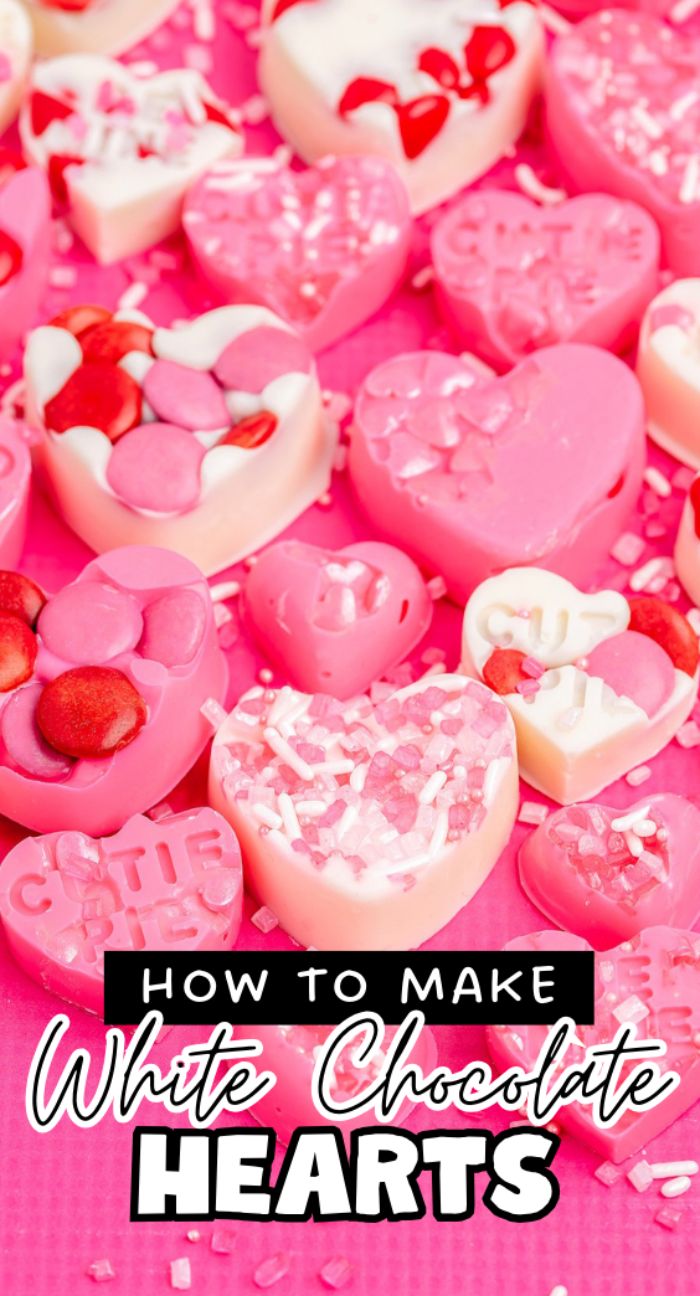 Various pink and white heart-shaped chocolates with sprinkles on a pink surface, perfect for diy valentine chocolate or learning how to make white chocolate hearts, with text overlay reading the title.