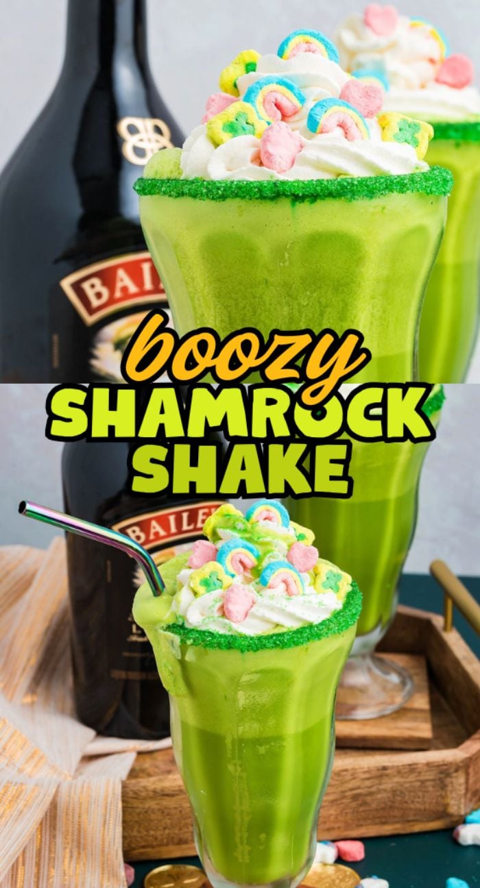 A boozy shamrock shake topped with whipped cream and colorful marshmallows, with a bottle of Baileys in the background.