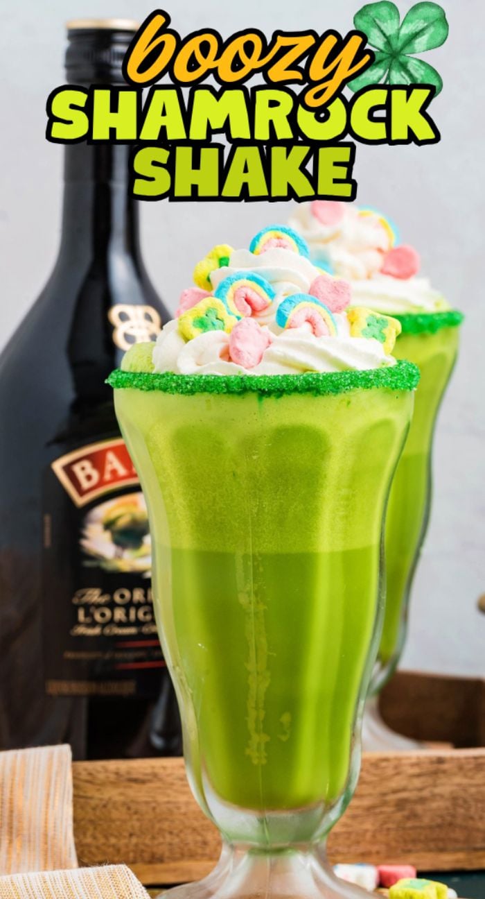 Green shamrock shakes with whipped cream, rainbow marshmallows, and a bottle of Baileys in the background—perfect for a festive Irish cream milkshake or a boozy shamrock shake to celebrate St. Patrick’s Day.