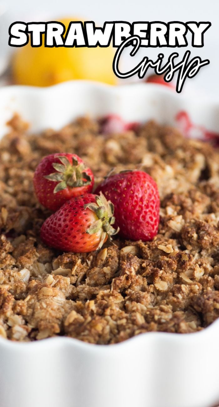 Baked strawberry crisp topped with fresh strawberries in a scalloped white dish; text reads "Strawberry Crisp," the best gluten free crisp recipe for a delightful baked dessert with fruit.