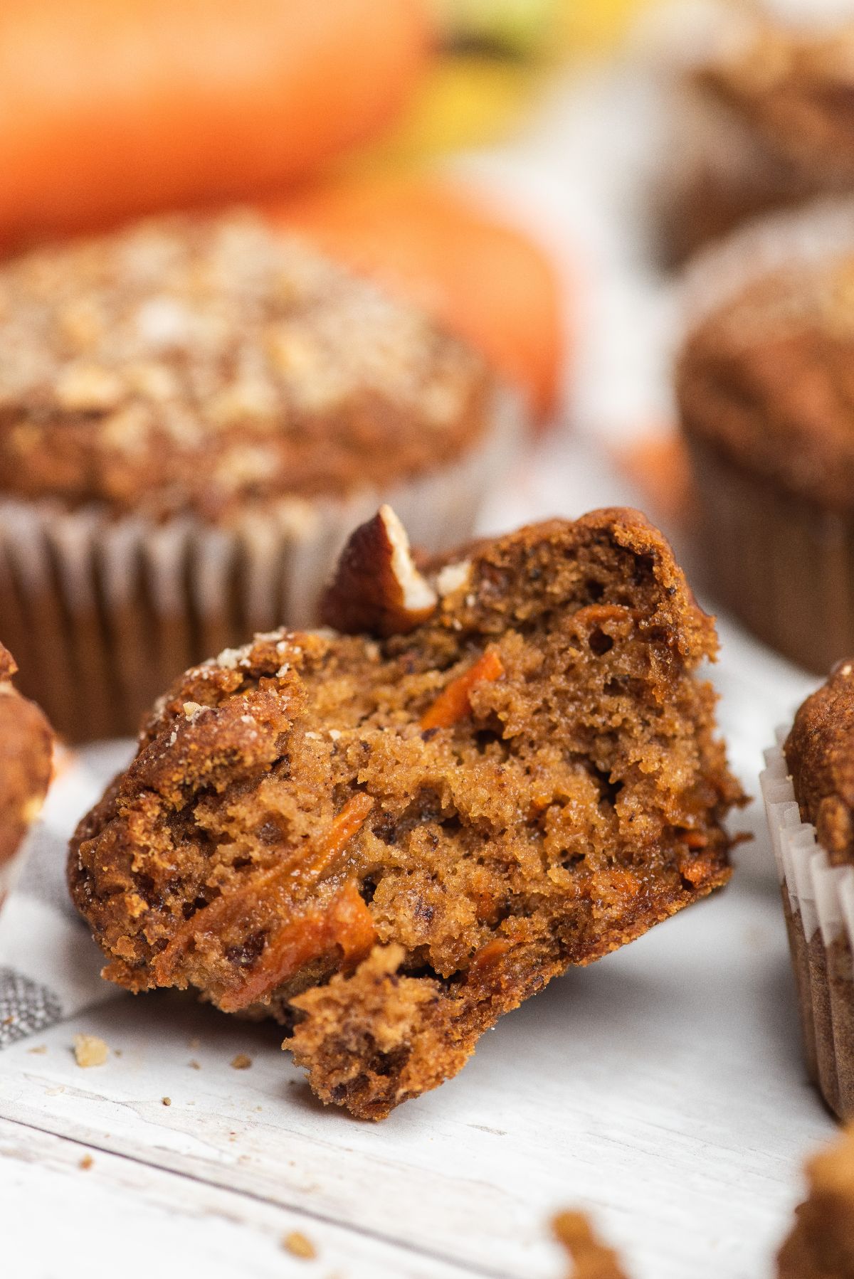 A close-up of a Morning Glory Muffin broken in half, showing its moist, textured interior with visible carrot shreds—perfect for those seeking delicious gluten free muffins.