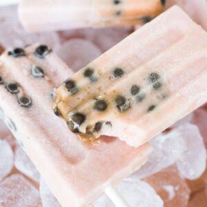 Watermelon boba popsicles with black seeds rest on ice cubes, surrounded by fresh watermelon slices.