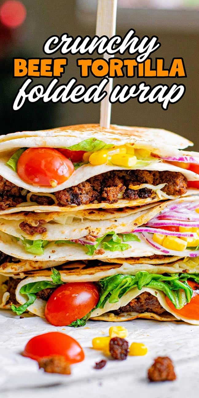 Stacked folded tortilla wraps filled with beef, lettuce, tomato, corn, cheese, and red onion.
