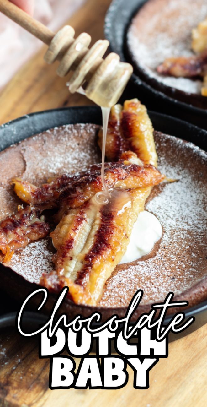 Honey is drizzled over sliced Chocolate Dutch Baby pancake on a plate dusted with powdered sugar, perfect for those seeking a unique chocolate pancake recipe.