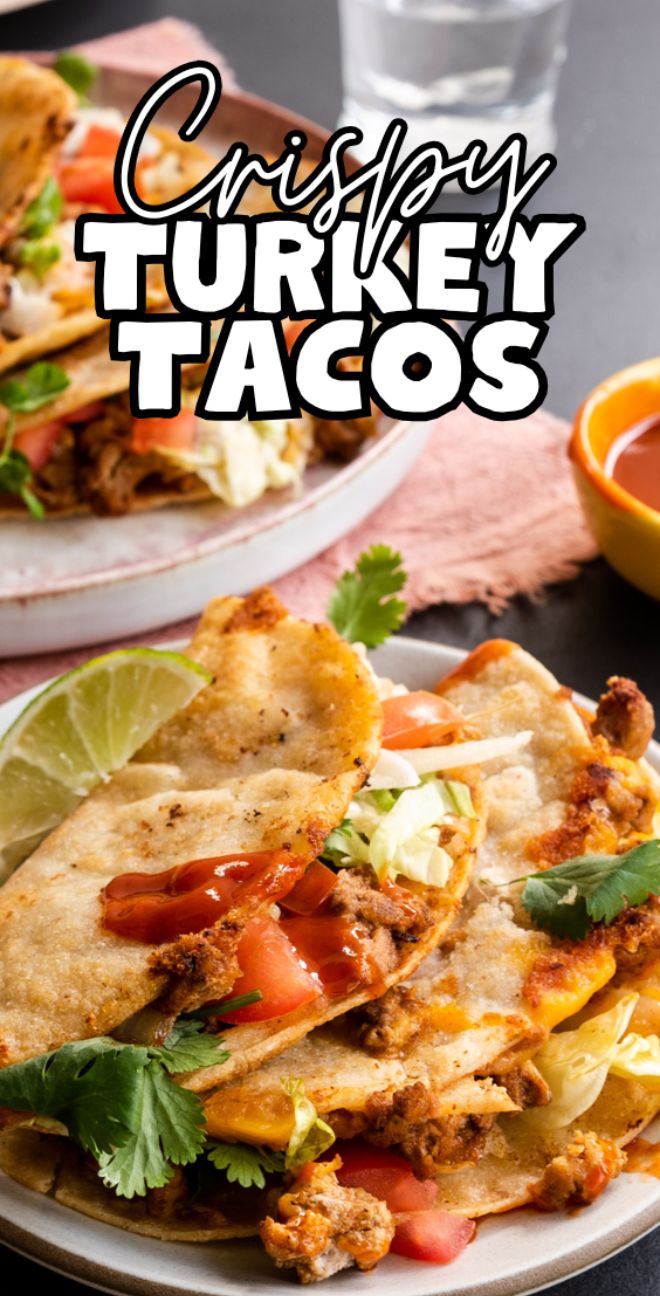 Three crispy turkey tacos with lettuce, tomato, cilantro, lime, and sauce on plates—this quick and easy dinner is the perfect recipe with ground turkey. Glass and salsa served nearby.