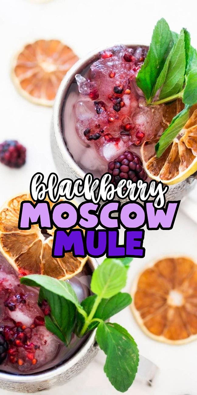 Two blackberry Moscow mules garnished with mint and dried citrus slices.