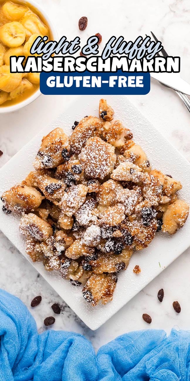 Gluten-free Kaiserschmarrn dusted with powdered sugar on a white plate, with raisins and banana slices nearby.