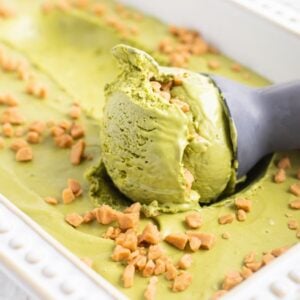 A scoop of green matcha ice cream with caramel bits in a white rectangular dish—an easy matcha ice cream recipe without a machine, perfect for dessert lovers.