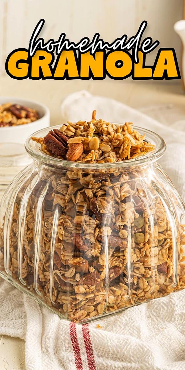 A glass jar filled with homemade granola on a towel, with text reading “homemade granola” above.