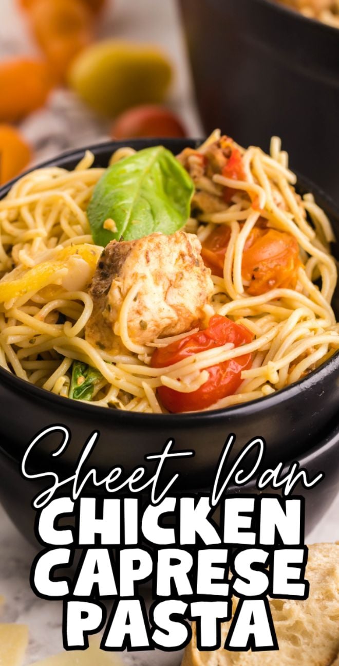 A bowl of Sheet Pan Chicken Caprese Pasta with cherry tomatoes, basil, and spaghetti made with chicken tenderloins, served in a black dish.
