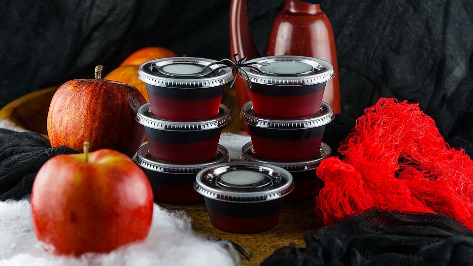 A group of red apple jelly cups on a table.