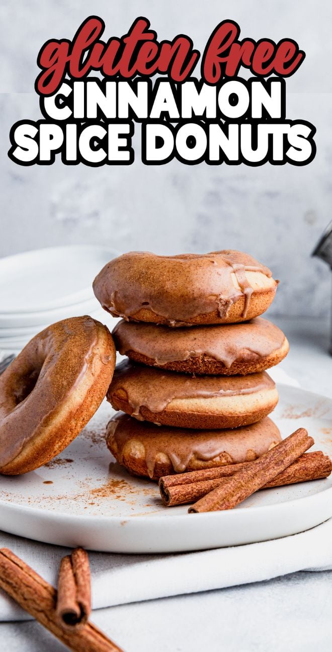 Stack of Gluten Free Cinnamon Spice Donuts on a plate with cinnamon sticks in front—these delicious oven baked donuts are perfect for anyone who loves gluten free baked goods.