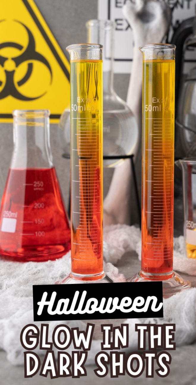 Two colorful measuring cylinders with Halloween decor showcase a Halloween Glow in the Dark Shots sign, perfect for serving a fluorescent neon cocktail that will light up any spooky celebration.