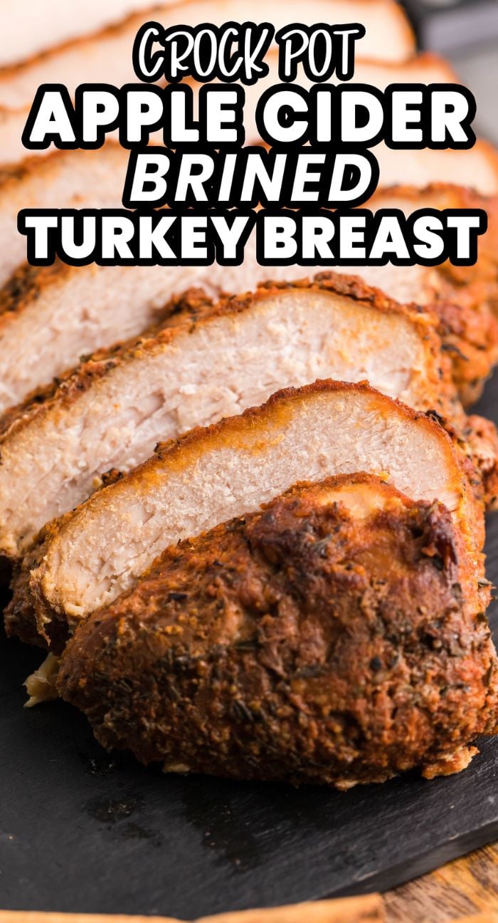 Sliced, seasoned turkey breast on a black platter with text: Slow Cooker Apple Cider Turkey Breast—the perfect easy brine for turkey breast!.