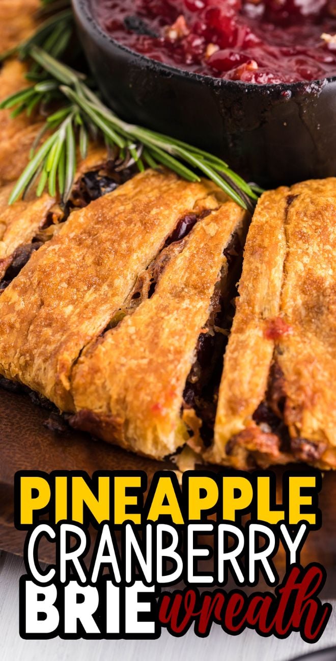Close-up of a sliced Pineapple Cranberry Brie Wreath, a delicious crescent wreath appetizer with rosemary and a bowl of cranberry sauce.