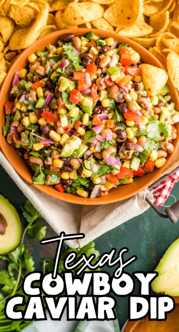 A bowl of Texas Cowboy Caviar dip, loaded with diced veggies, beans, and corn chips, makes a perfect healthy summer BBQ dip—served with avocado and surrounded by crispy chips for the ultimate Southwest vegan appetizer.