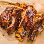 Barbecue ribs with a glossy glaze, sliced and served on parchment paper—the Best Dry Rib Rub makes these Air Fryer BBQ Ribs perfect for a quick dinner.
