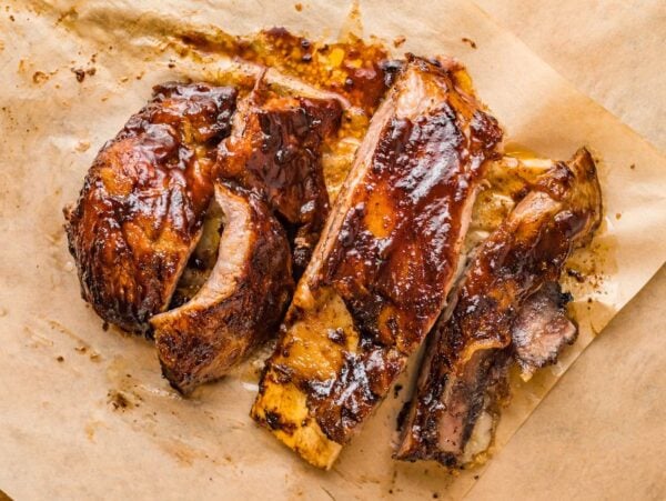 Barbecue ribs with a glossy glaze, sliced and served on parchment paper—the Best Dry Rib Rub makes these Air Fryer BBQ Ribs perfect for a quick dinner.