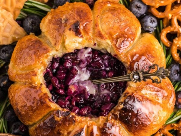 Brie and puff pastry baked in an air fryer, filled with blueberries and served with pretzels, waffle cookies, and fresh berries—this blueberry brie appetizer is perfect for any gathering.
