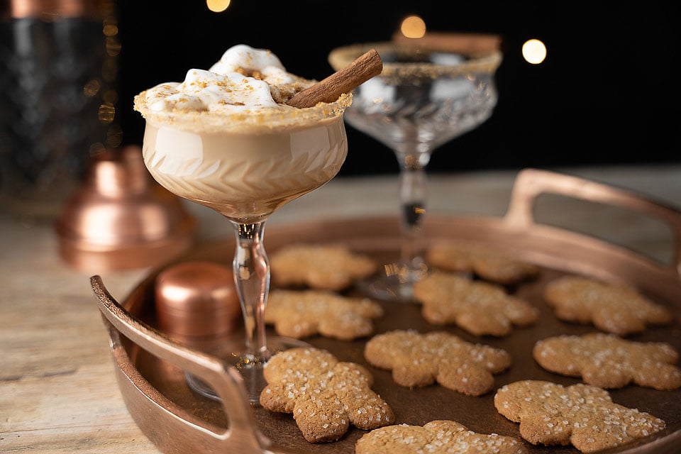 A drink with whipped cream and cookies on a tray.