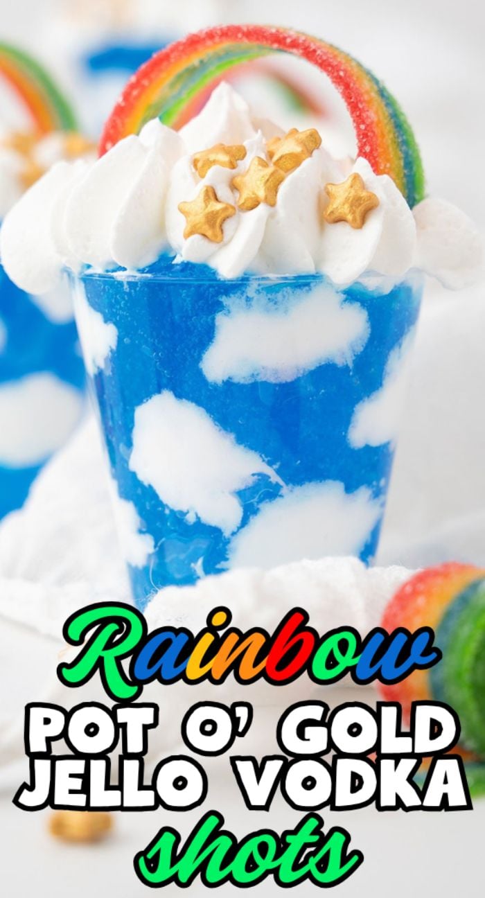 Celebrate Pride Day with these Rainbow Pot O' Gold Jello Vodka Shots—blue and white jello vodka shots topped with whipped cream, gold star sprinkles, and a rainbow candy for a festive, colorful treat.