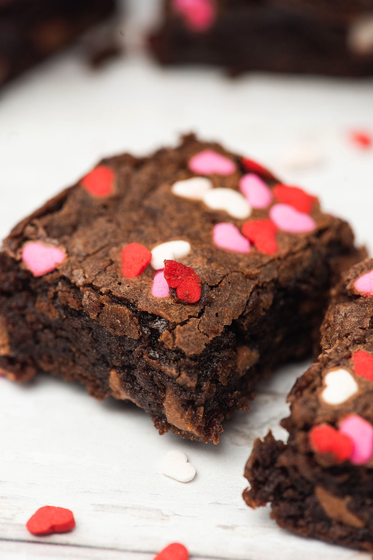 A close-up of Valentine brownies topped with red, pink, and white heart-shaped sprinkles—a sweet Valentine treat perfect for celebrating love.