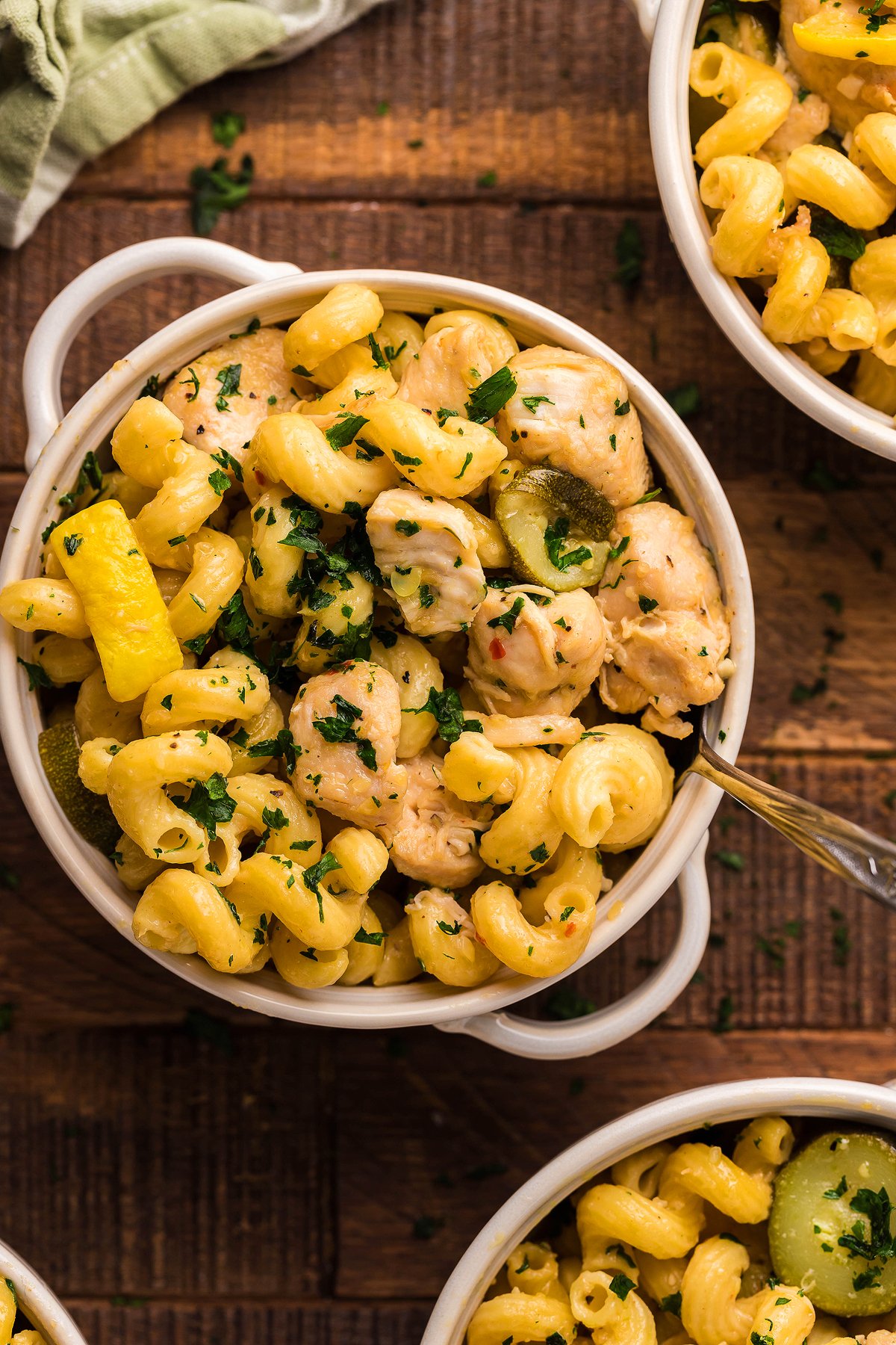 A bowl of Pasta with Zucchini and Squash, tender chicken, and fresh herbs sits on a wooden table—an easy instant pot pasta dinner for any night.