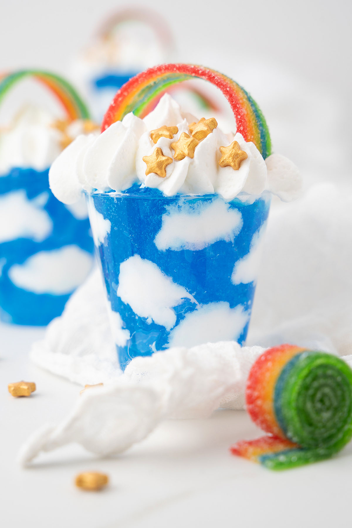A blue dessert with Jello sky and cool whip clouds, topped with rainbows&mdash;perfect for St. Patrick's Day or Pride Day celebrations.