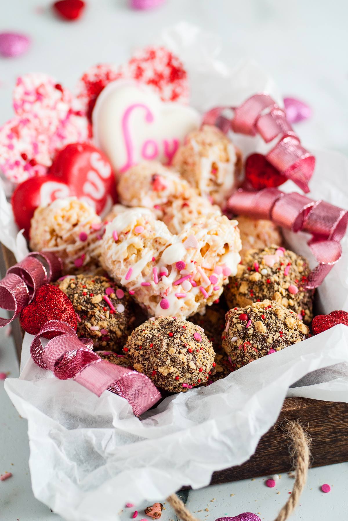 Assorted Valentine's Day treats in a valentine treat box, featuring heart shapes, sprinkles, and red ribbon decorations—perfect for gifting or making with easy recipes at home.