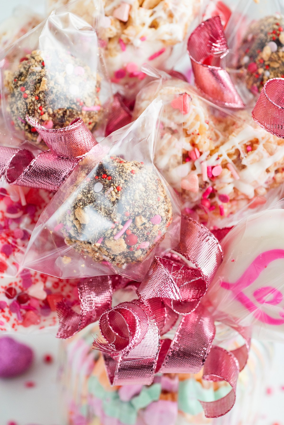 Chocolate and sprinkle-covered treats in clear bags tied with shiny pink ribbons, arranged in a festive bouquet—perfect for an eye-catching valentine treat box or as part of your favorite easy recipes for gifting.