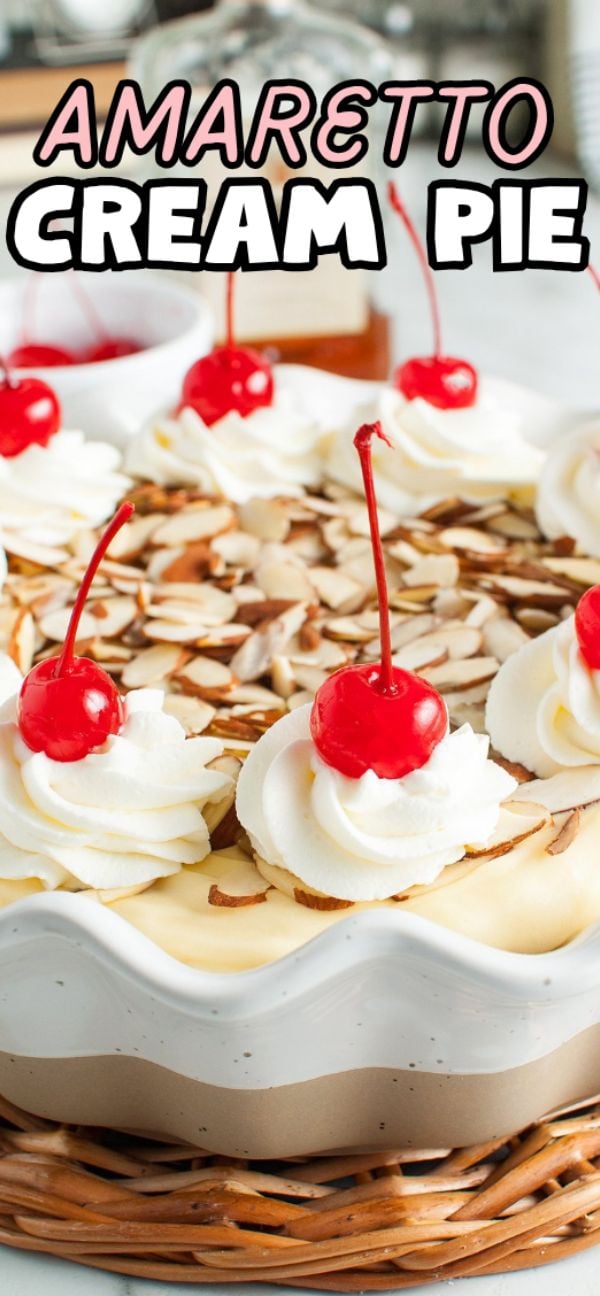 A luscious Amaretto Cream Pie topped with whipped cream, cherries, and almond slices in a decorative pie dish, featuring a delicate almond crust.