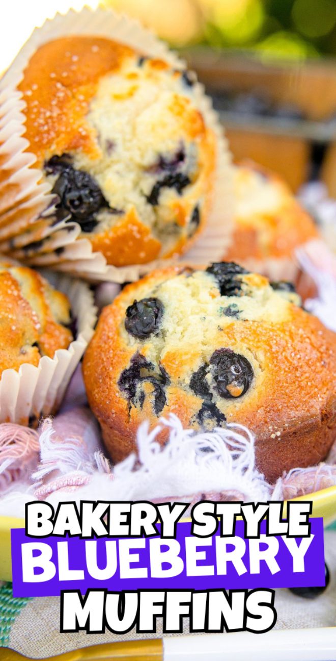Close-up of super moist, bakery style blueberry muffins in paper liners, with bold text reading "Bakery Style Blueberry Muffins.