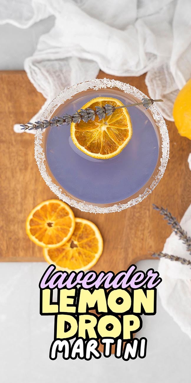 A lavender lemon drop martini with dried lemon and lavender on a wooden board, text overlay at the bottom.