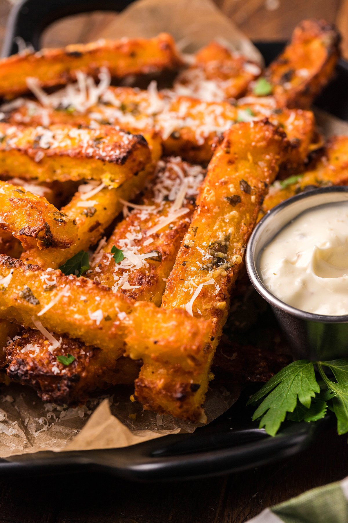 Crispy cornmeal french fries, air fried polenta topped with grated cheese, served as a side dish or appetizer with creamy dipping sauce and fresh parsley.