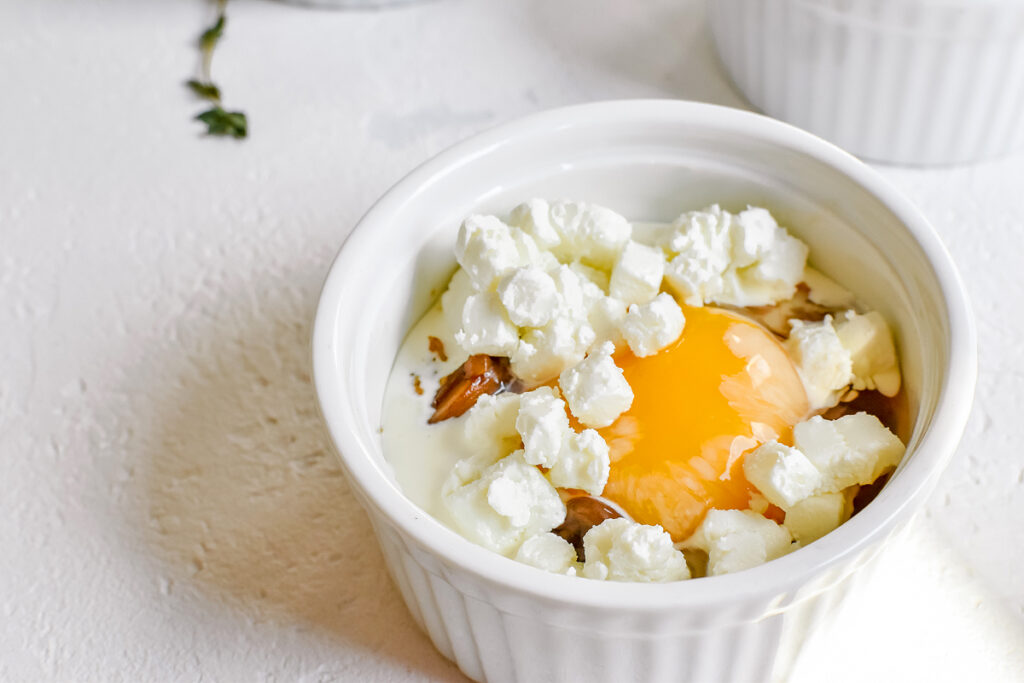 A white bowl with egg recipes and feta cheese.