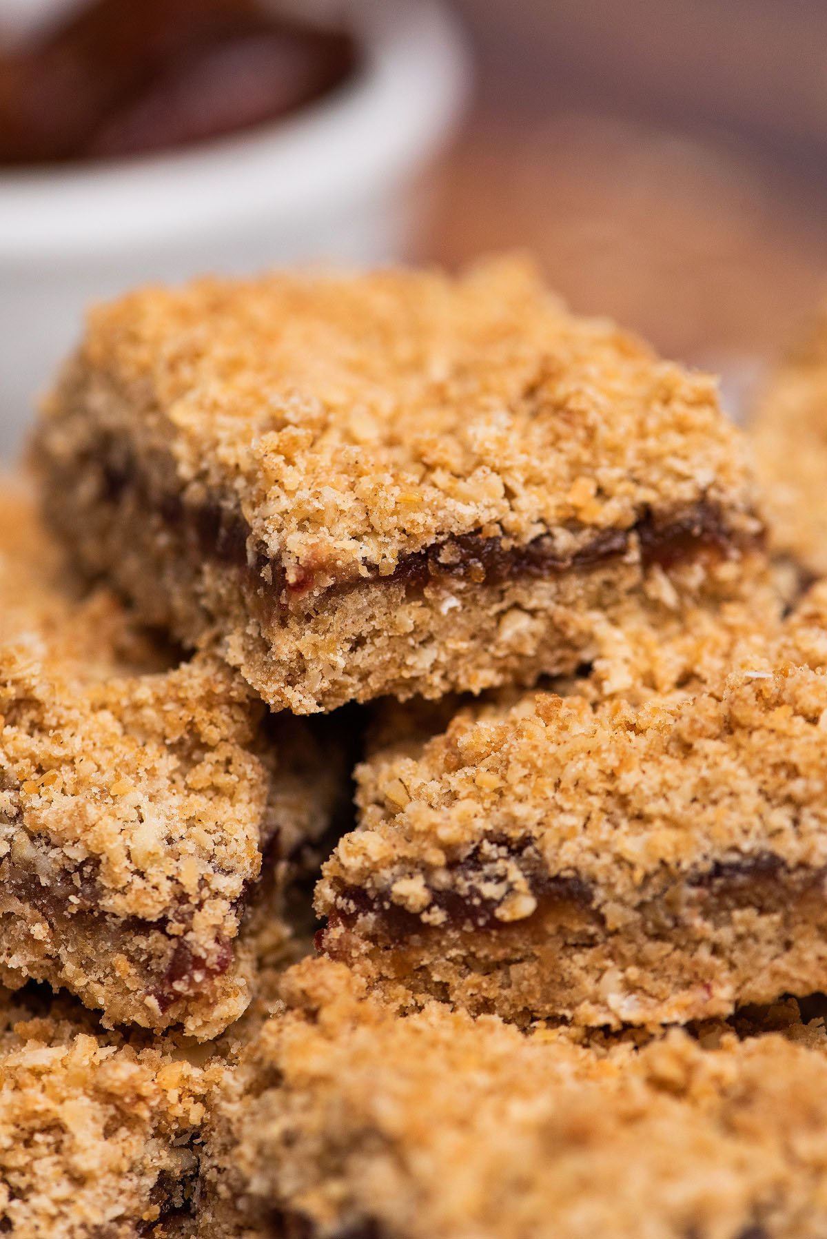 Close-up of stacked oat crumble bars with a dark fruit filling, featuring an Oatmeal Crumble Topping and a rich texture perfect for any date crumble recipe.