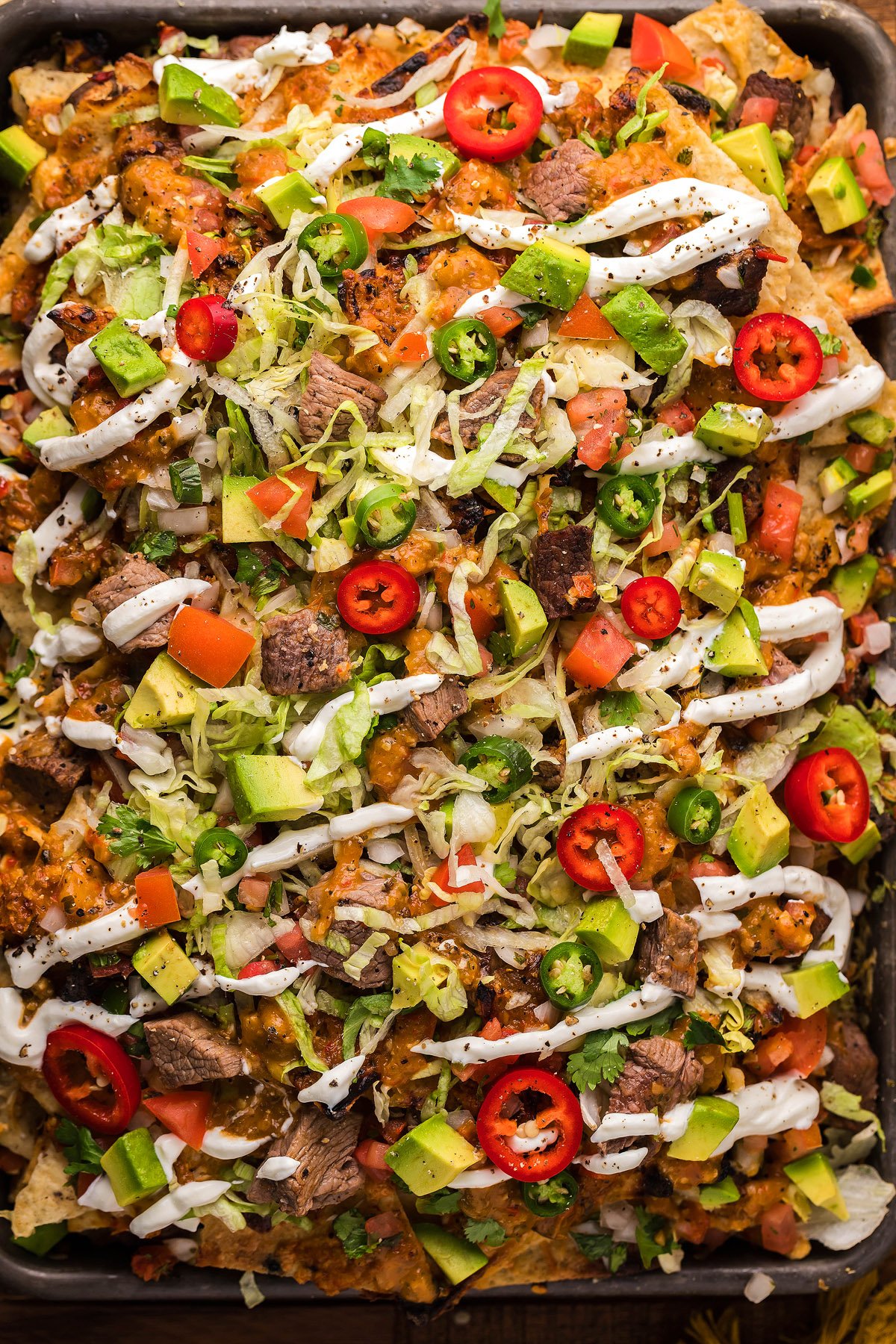 Loaded Mexican steak nachos topped with avocado, cheese, lettuce, tomato, jalapeños, and drizzled with sour cream. Perfectly paired with our zesty homemade salsa or Tomatillo Serrano Salsa for an extra kick.