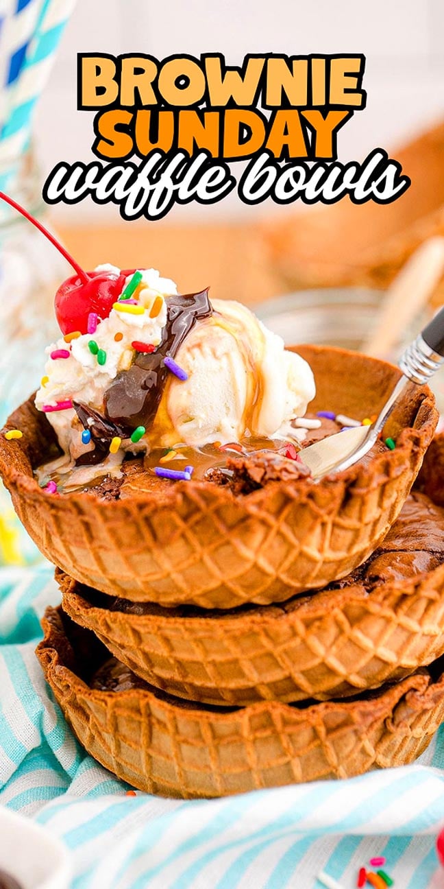 Three stacked waffle bowls filled with brownies, ice cream, whipped cream, sprinkles, and a cherry.