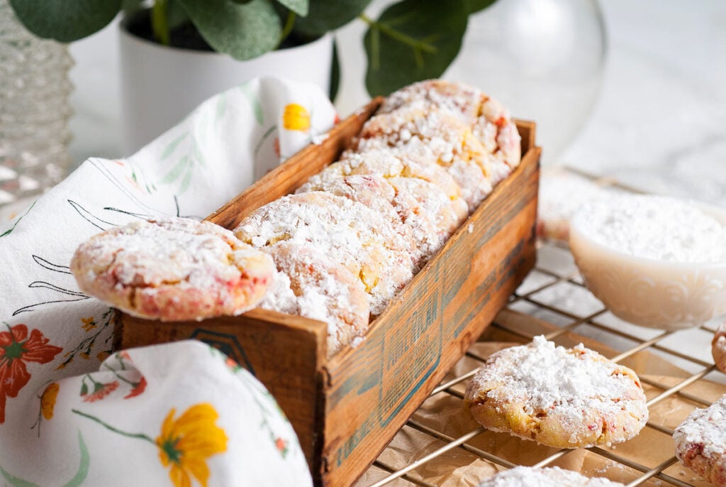 Lemon and strawberry powdered sugar cookies in a wooden box.