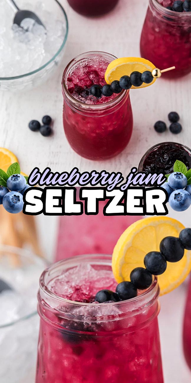 Mason jar of blueberry jam seltzer, garnished with lemon and blueberries, surrounded by ice and berries.