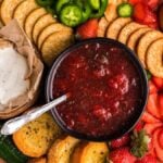 A delightful cheese or charcuterie board featuring crackers, cream cheese, Strawberry Jalapeño Jam, fresh strawberries, jalapeños, and toasted bread—perfect for sharing.