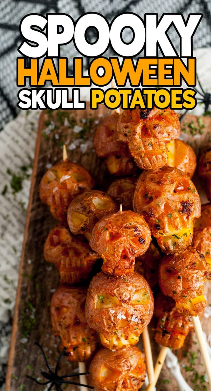 Skewers of spooky Halloween skull potatoes, roasted to perfection and arranged on a wooden board, make a fun Halloween side dish or appetizer with shrunken head vibes and festive decoration.