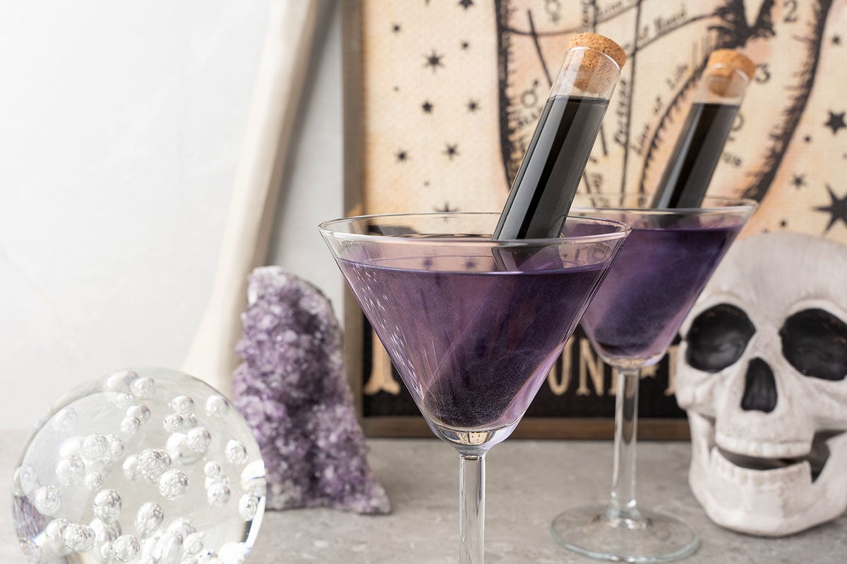 Black Magic Rum Halloween Cocktail with two vials of black rum in the glass