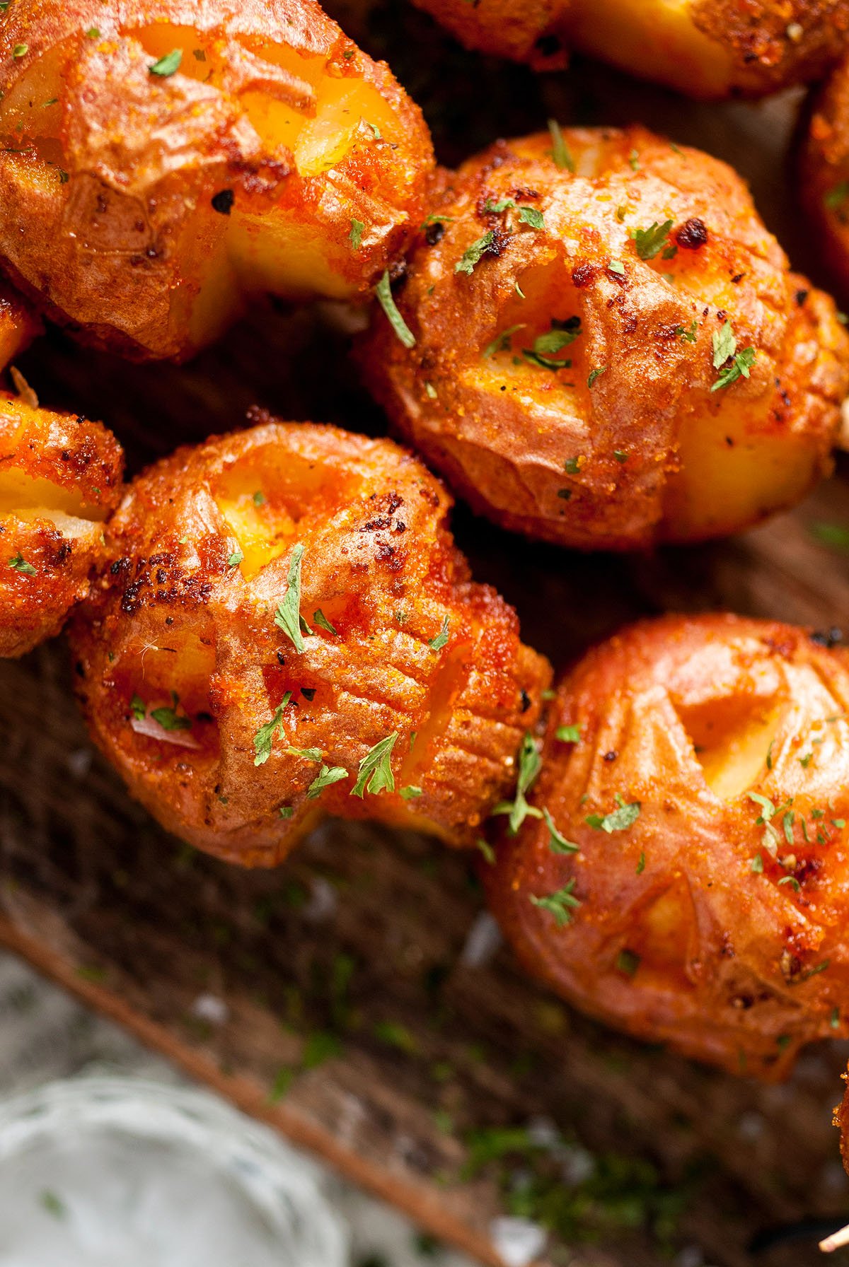 Close-up of crispy, golden roasted potatoes with herbs sprinkled on top, featuring Spooky Halloween Skull Potatoes for a festive twist.